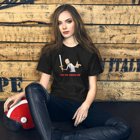 Woman wearing black T-shirt with cartoon warrior and text I am the chosen one, sitting by wooden wall with red helmet
